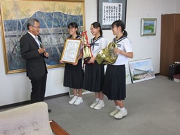 写真：吹奏楽部員と教育長（ななめ）