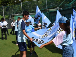 写真：選手にフラッグを手渡す児童